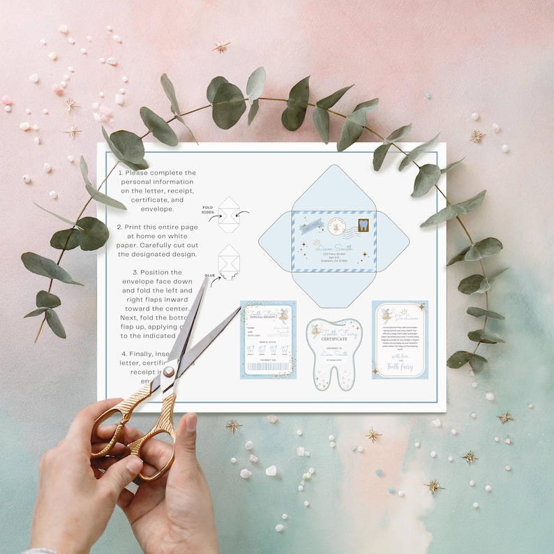 May include: A light blue Tooth Fairy kit with instructions, envelope, certificate, and receipt. The kit includes a diagram of how to fold the envelope. Gold scissors are cutting the paper. Eucalyptus and star decorations surround the kit.