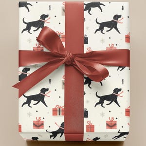 May include: White wrapping paper with a repeating pattern of black dogs and red gift boxes. A red ribbon is tied around the paper with a bow in the center.