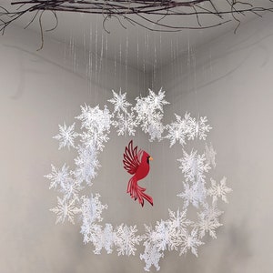 paper snowflake wreath with red cardinal ornament hanging in center