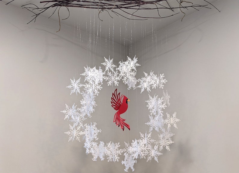 paper snowflake wreath with red cardinal ornament hanging in center