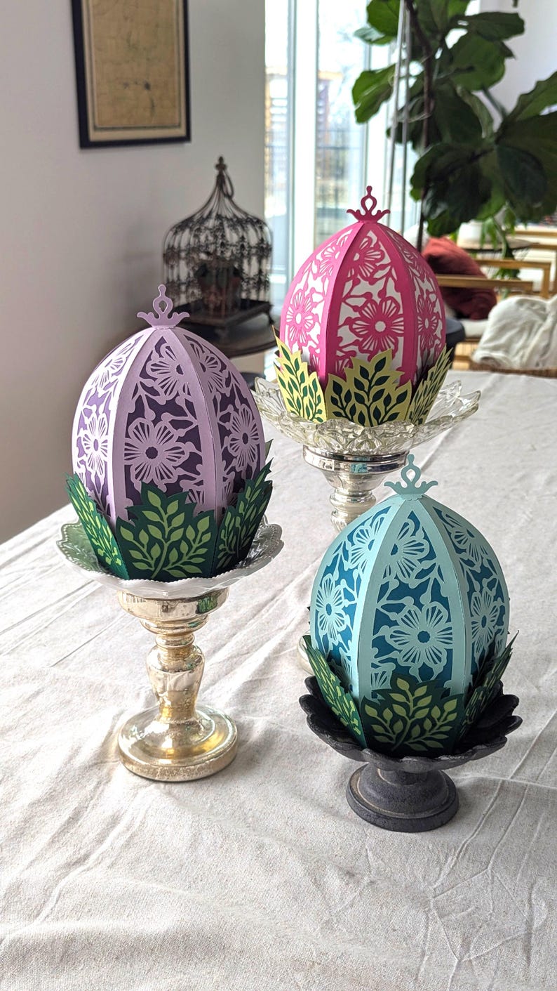 Floral Easter egg basket decor in pink, purple, and blue displayed on pedestal stands, styled as light-up spring table centerpieces for Easter and seasonal home decor.