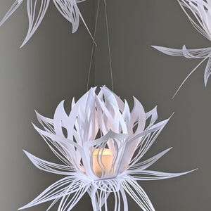 White paper lotus lantern hanging with soft LED light inside