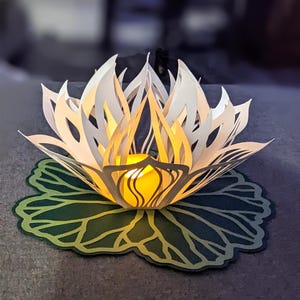 Paper lotus lantern with LED tealight glowing on leaf base centerpiece