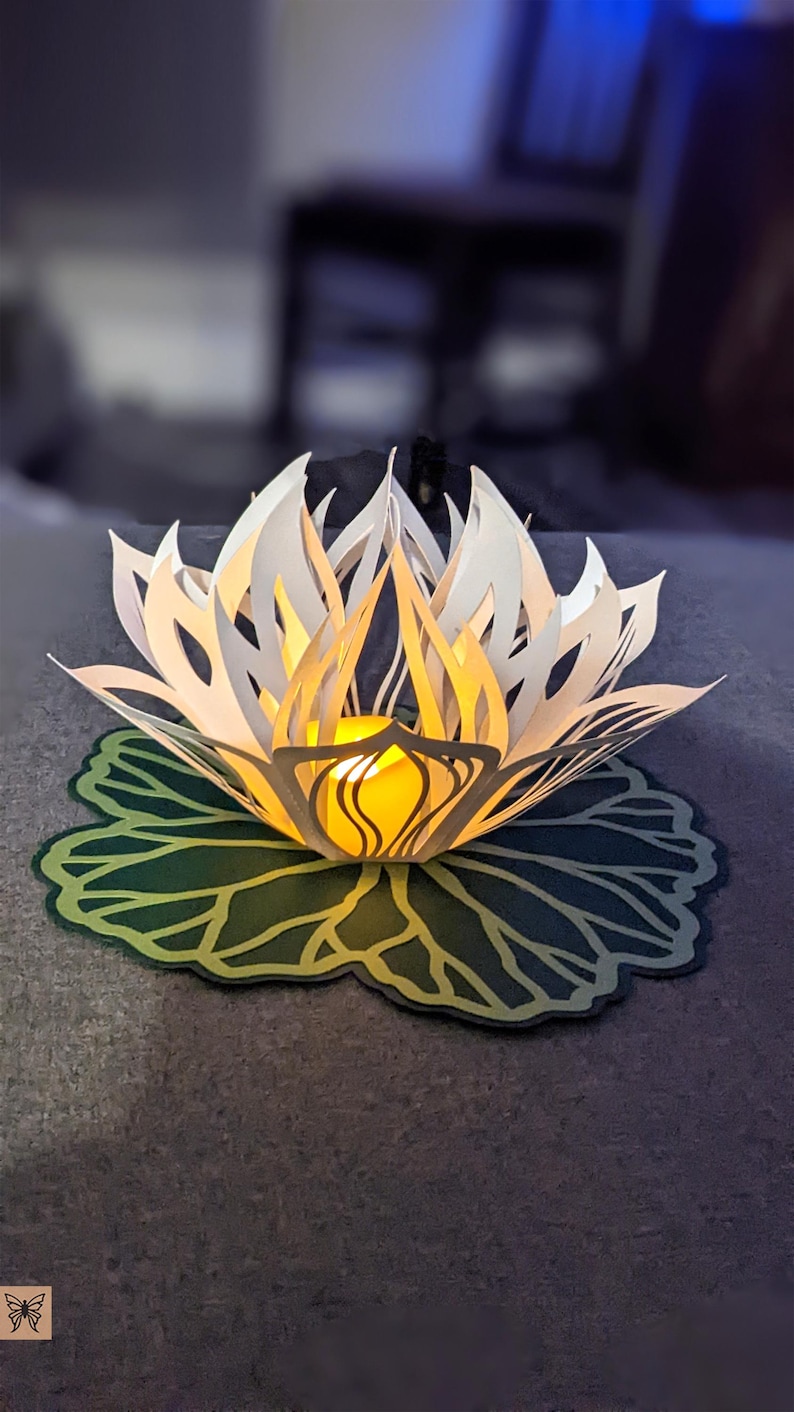 Paper lotus lantern with LED tealight glowing on leaf base centerpiece