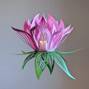 Pink and green 3D paper lotus lantern glowing with an LED tealight, crafted from a downloadable SVG file for Cricut and Silhouette machines.