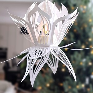 White paper lotus lantern hanging with soft light in cozy home decor setting