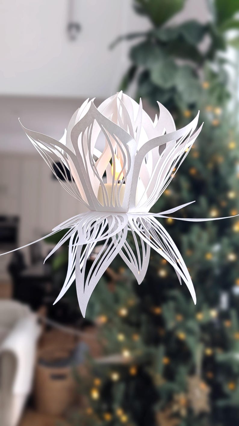 White paper lotus lantern hanging with soft light in cozy home decor setting