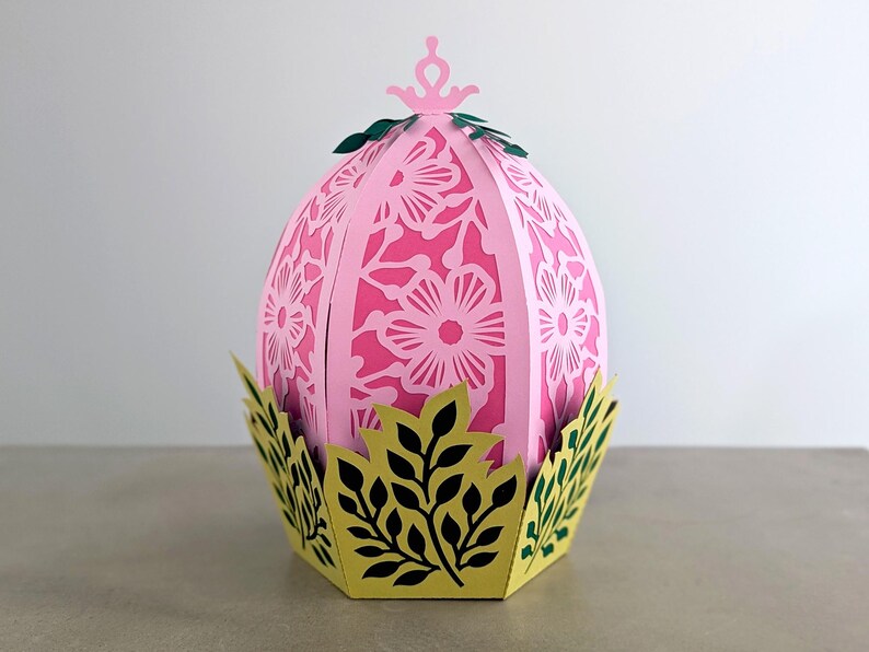 Floral Easter egg basket decor in pink displayed in a decorative leaf base, styled as a spring table centerpiece and Easter home accent.