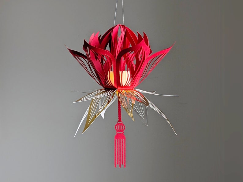 Red 3D paper lotus lantern with gold accents and tassel, made from an SVG file for Cricut; hanging Lunar New Year flower decor.