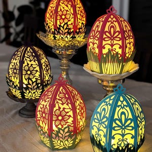 Light-up floral Easter egg basket decor in multiple colors displayed on pedestal stands, glowing with flameless tealights and styled as spring table centerpieces for Easter home decor.