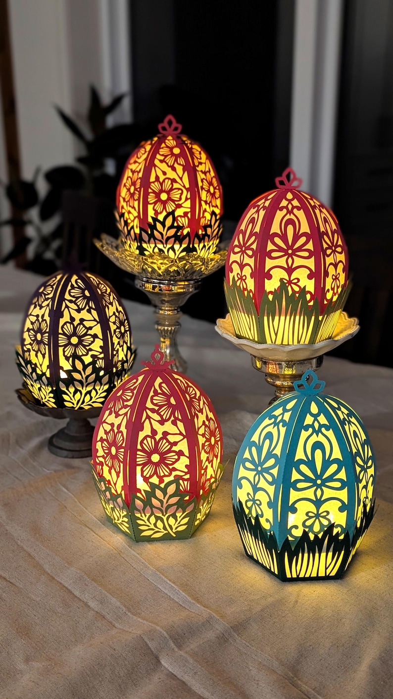 Light-up floral Easter egg basket decor in multiple colors displayed on pedestal stands, glowing with flameless tealights and styled as spring table centerpieces for Easter home decor.