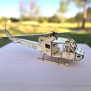 Maqueta de madera cortada a láser en 3D del helicóptero UH-1 Huey de gran tamaño con pegamento incluido. Gran detalle, aspas de rotor móviles y fácil montaje. Fabricado en EE. UU.