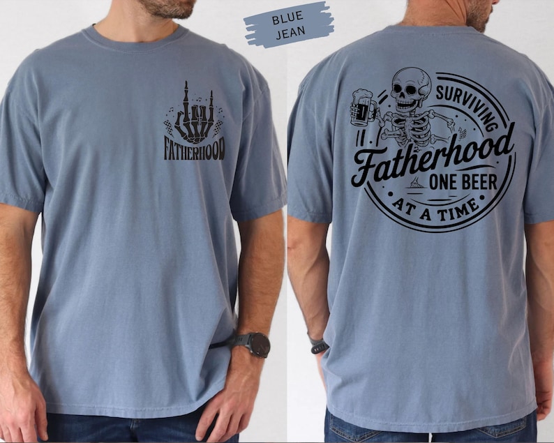 Pu&ograve; includere: T-shirt blu jeans a maniche corte con grafiche nere. Il davanti presenta una mano di scheletro e la scritta "FATHERHOOD". Il retro mostra uno scheletro con una birra e la scritta "SURVIVING FATHERHOOD ONE BEER AT A TIME".