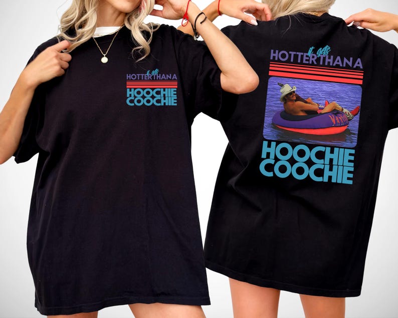 May include: A black t-shirt featuring a graphic print on the front and back. The front shows the text "IT GETS HOTTERTHANA HOOCHIE COOCHIE" in blue and red. The back displays the same text with a photo of a person in a tube on water.