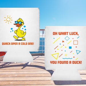 Puede incluir: Dos enfriadores de latas blancos con diseños diferentes. El primer enfriador presenta un pato de dibujos animados con gafas de sol y el texto "Quack open a cold one!" El segundo enfriador presenta un patrón geométrico con el texto "Oh what luck, you found a duck!"
