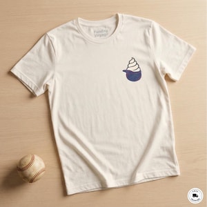 May include: Off-white t-shirt with a small ice cream cone graphic on the chest. The ice cream cone is white with a blue base. The text "Funday Voyage" is printed on the shirt. A baseball is in the lower left corner.