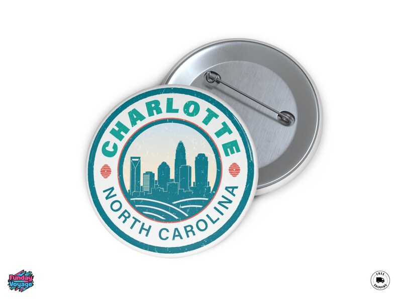 Pu&ograve; includere: Un distintivo rotondo con un design turchese e bianco dello skyline di Charlotte, Carolina del Nord. Il testo "CHARLOTTE NORTH CAROLINA" &egrave; stampato sul bordo. Un secondo distintivo &egrave; visibile sullo sfondo.