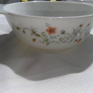 May include: White ceramic bowl with a floral design featuring small pink and orange flowers and green leaves.