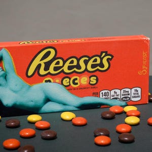 Pintura de figura sobre una caja de dulces de teatro Reese's Pieces. Pintura de dulces, arte pop.