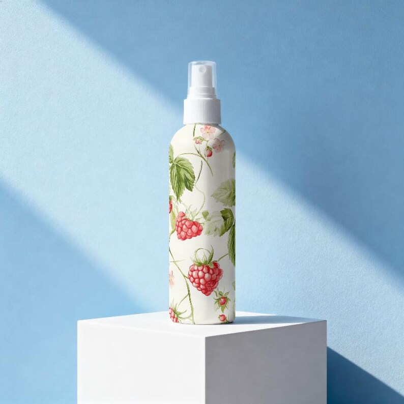 May include: White spray bottle with a floral design featuring red raspberries, green leaves, and pink flowers. The bottle is on a white cube against a light blue background.