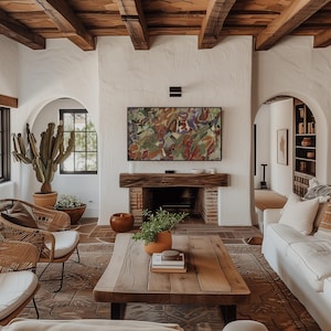 May include: A living room with a rustic design. It features a wooden coffee table, woven chairs, a fireplace with a painting above, and a cactus in a terracotta pot. The room has a warm, inviting atmosphere with exposed wooden beams.