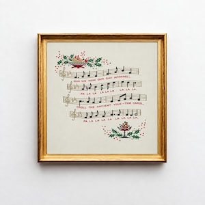 Puede incluir: Una impresión cuadrada enmarcada que presenta notación musical y la letra de un villancico. El texto dice: Don we now our gay apparel, Fa la la la la la la la la, Troll the ancient Yule-tide carol, Fa la la la la la la la la. Decorado con acebo y bayas.