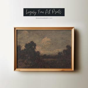 May include: A framed print of a landscape painting depicting a field with trees in the foreground and a cloudy sky with a moon in the background. The painting is in a brown wooden frame.