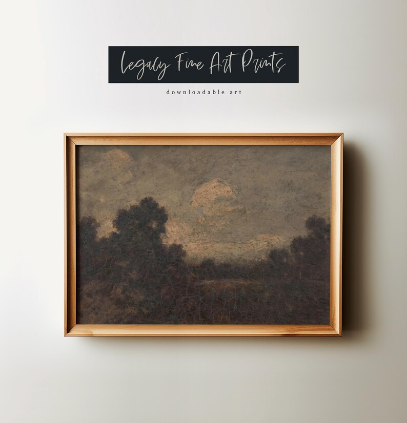 May include: A framed print of a landscape painting depicting a field with trees in the foreground and a cloudy sky with a moon in the background. The painting is in a brown wooden frame.