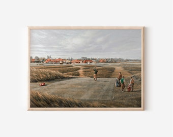May include: A framed print of a golf course scene. The artwork shows a golfer in mid-swing, with other golfers and golf bags. The background features a course with buildings and a cloudy sky. The frame is light-coloured wood.