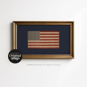 May include: A rectangular gold-toned frame containing digital artwork of an American flag with a gingham-patterned blue canton and horizontal red and white stripes, set against a dark navy background with the text SAMSUNG Frame TV Digital Artwork.