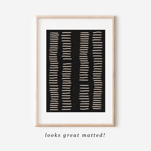 May include: A black and white abstract art print with a geometric pattern of thin lines. The print is framed in a light wood frame.