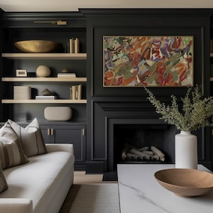 May include: A living room featuring a black cabinet and fireplace. The shelves display decorative items, including a gold bowl and books. A white sofa with patterned cushions sits in front of the cabinet. An abstract painting hangs above the fireplace.