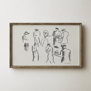 Op de afbeelding: Een ingelijst kunstwerk met een houtskoolschets van verschillende figuren in diverse poses. De figuren worden weergegeven met losse, expressieve lijnen. De lijst heeft een lichtbruine kleur.