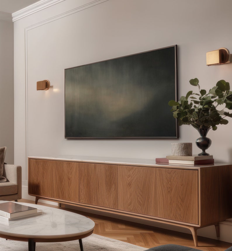 May include: A modern living room with a wooden cabinet, a white marble coffee table, and a large abstract painting above the cabinet. Two gold wall sconces are on either side of the painting.