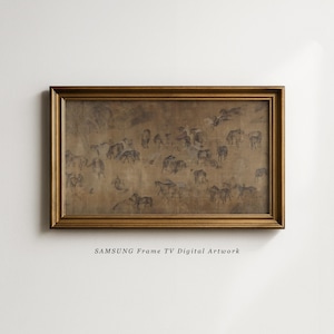 May include: A framed artwork with a gold-coloured frame. The artwork depicts a sepia-toned scene of numerous figures, possibly animals, in a field. The text "SAMSUNG Frame TV Digital Artwork" is printed at the bottom of the frame.