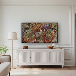 May include: A living room with a white cabinet, topped with decorative items, and a large abstract painting. A floor lamp with a beige shade stands beside a cream sofa with a rust-coloured cushion. The room has wooden flooring.