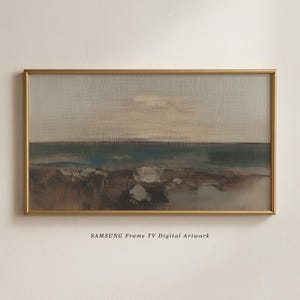 May include: A framed digital artwork depicting a landscape. The artwork uses a muted palette of blues, browns, and greys, with a gold frame. The text "SAMSUNG Frame TV Digital Artwork" is at the bottom of the image.