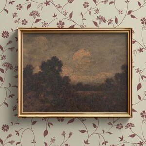 May include: A framed landscape painting depicting a misty, wooded scene with a golden sky. The painting is in a simple, gold frame.