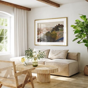 Puede incluir: Un sof&aacute; seccional beige claro con una mesa de caf&eacute; de madera y una planta en maceta en una cesta tejida. Una pintura de paisaje enmarcada cuelga en la pared detr&aacute;s del sof&aacute;.