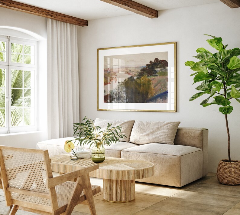 Puede incluir: Un sof&aacute; seccional beige claro con una mesa de caf&eacute; de madera y una planta en maceta en una cesta tejida. Una pintura de paisaje enmarcada cuelga en la pared detr&aacute;s del sof&aacute;.