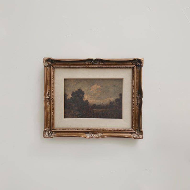 May include: A framed landscape painting with a dark brown wooden frame. The painting depicts a cloudy sky over a field of trees.