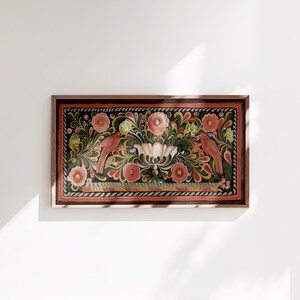 Puede incluir: Una obra de arte enmarcada que presenta un dise&ntilde;o tradicional de arte popular con p&aacute;jaros rojos, flores rosas y hojas verdes sobre un fondo negro.