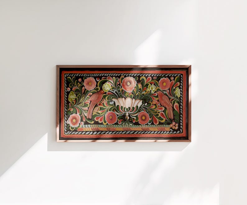 Puede incluir: Una obra de arte enmarcada que presenta un dise&ntilde;o tradicional de arte popular con p&aacute;jaros rojos, flores rosas y hojas verdes sobre un fondo negro.