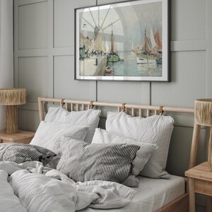 K&ouml;nnte beinhalten: Ein Schlafzimmer mit einem Holzbettgestell und wei&szlig;er Bettw&auml;sche aus Leinen. Das Kopfteil hat Lederriemen. &Uuml;ber dem Bett h&auml;ngt ein gerahmtes Gem&auml;lde einer Seest&uuml;ck. Das Gem&auml;lde zeigt eine Hafenszene mit Booten und einem Leuchtturm.