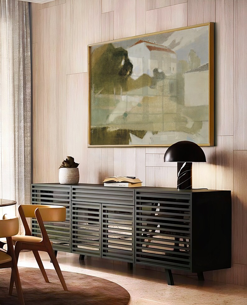 May include: A black cabinet with slatted doors and a wood top. The cabinet is in a modern living room with a large abstract painting on the wall behind it. A lamp with a black shade sits on the cabinet.