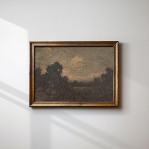 May include: A framed landscape painting depicting a forest scene with a cloudy sky. The painting is in a brown wooden frame.