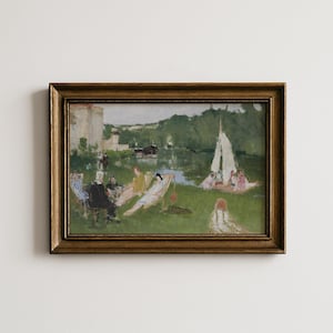 May include: A framed landscape painting depicting a group of people relaxing on a green lawn near a river with a sailboat. The scene includes figures in various clothing, trees, and a building in the distance, all enclosed in a dark gold frame.