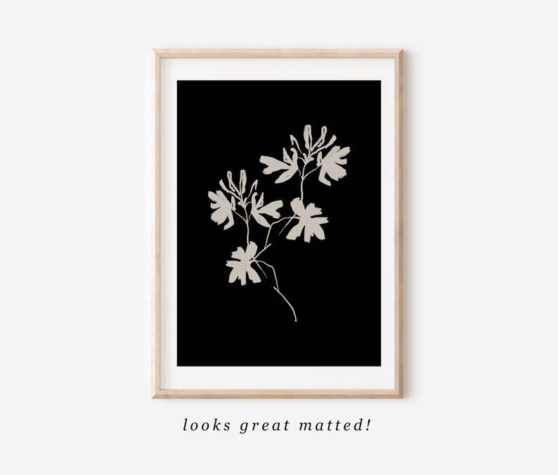 May include: A black and white minimalist art print featuring a stylized floral design. The print depicts a single stem with several delicate flowers and leaves.