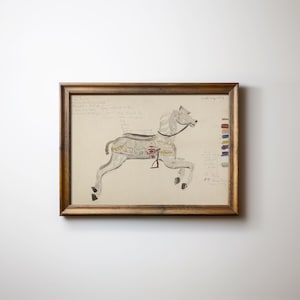 Puede incluir: Un dibujo enmarcado de un caballo de carrusel blanco con un corazón rojo en el pecho. El dibujo está en papel beige con notas escritas a mano y una paleta de colores.