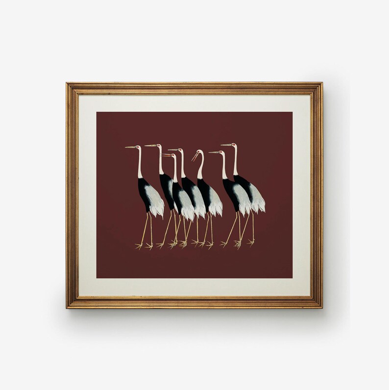 May include: A framed print of a line of seven black and white cranes with red beaks walking in a single file line on a maroon background.